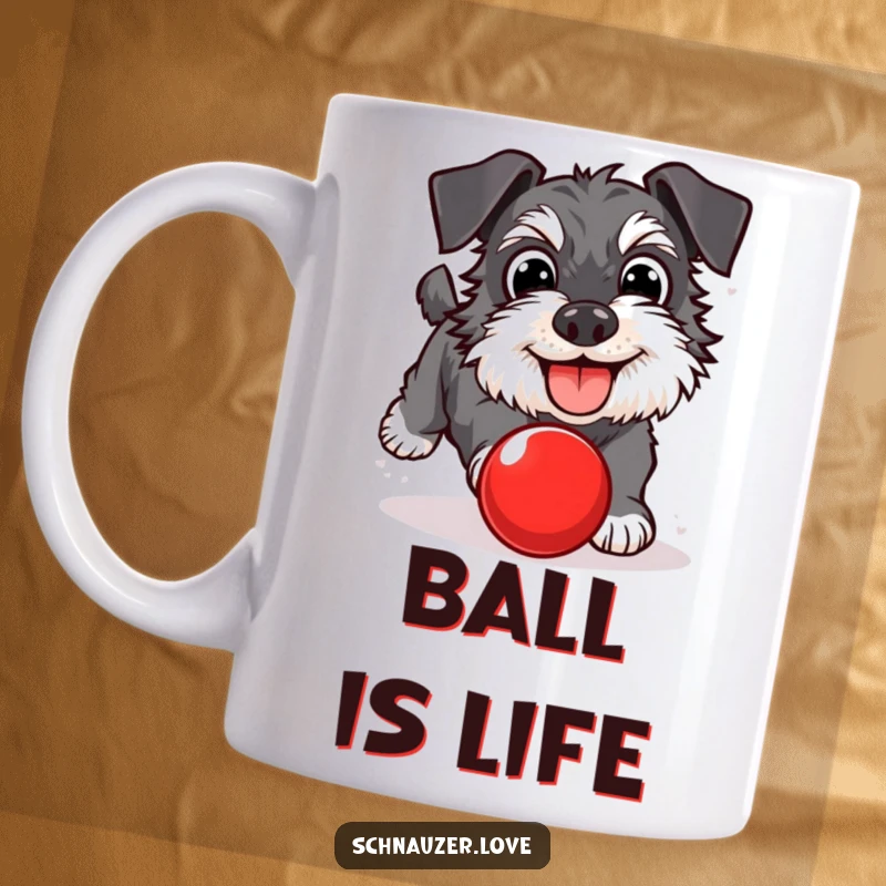 Funny Schnauzer Mug: A happy dog with wide eyes, joyfully chasing a red bouncing ball. A playful and humorous gift for schnauzer enthusiasts.