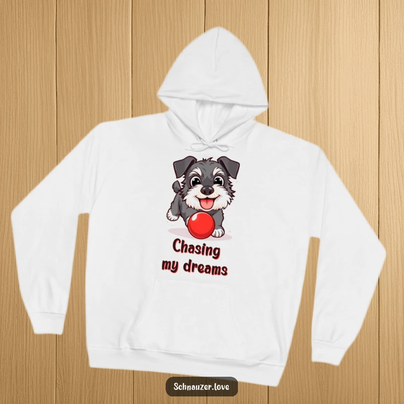 Funny Schnauzer Hoodie: A happy schnauzer with wide eyes, chasing a red ball. Cozy and humorous, a perfect funny gift.